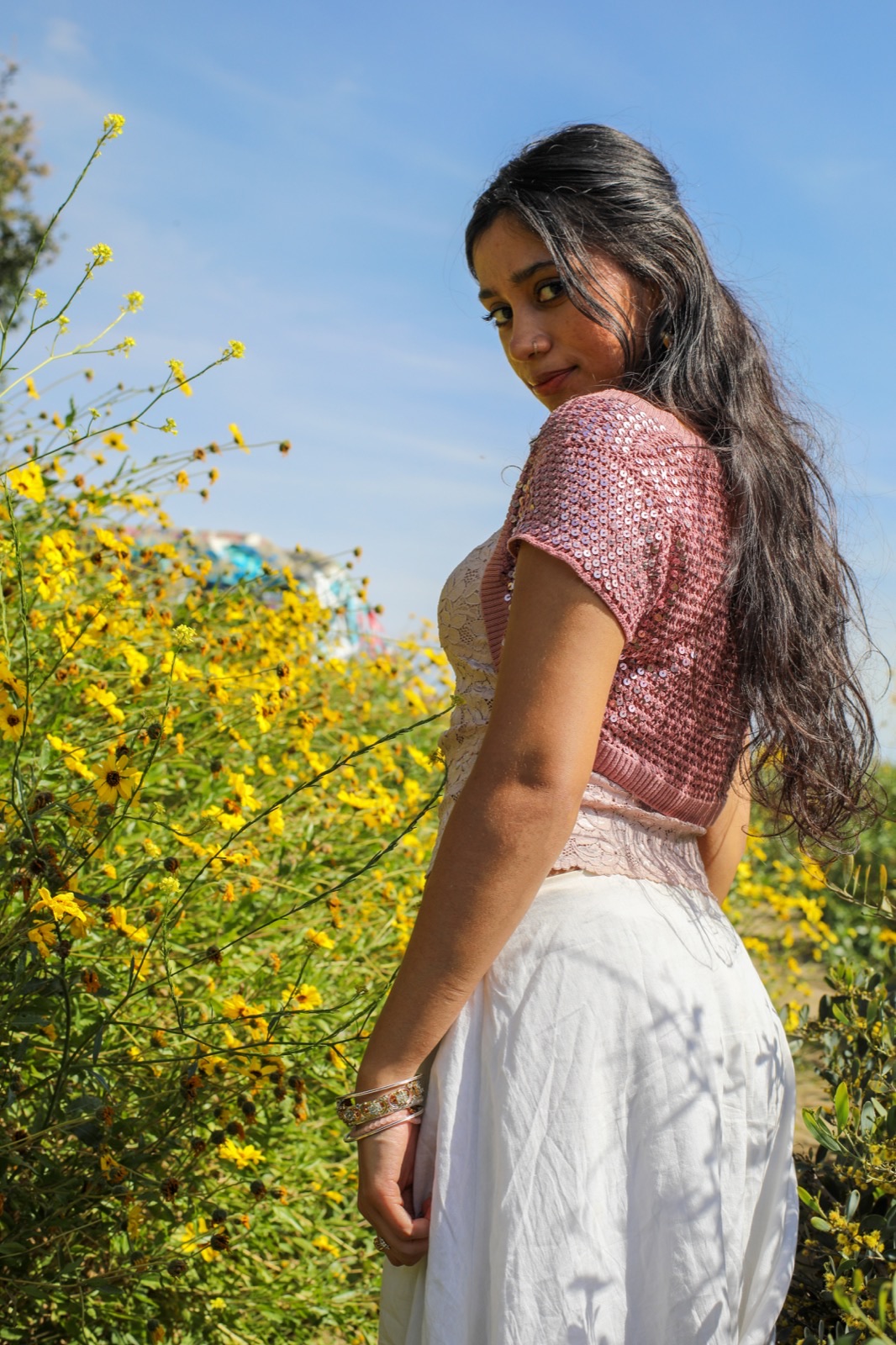 Creative portrait — looking over shoulder among yellow wildflowers