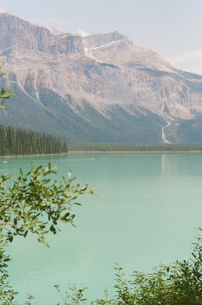 Turquoise lake with mountain and canoe