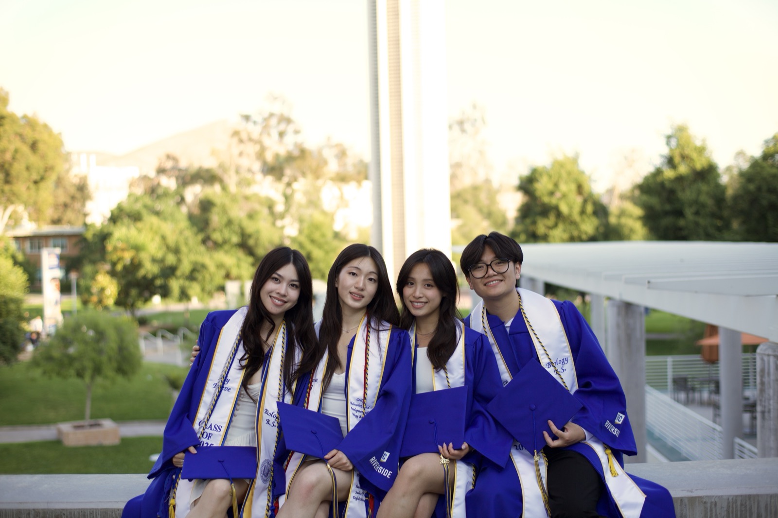 Group sitting at overlook in blue gowns
