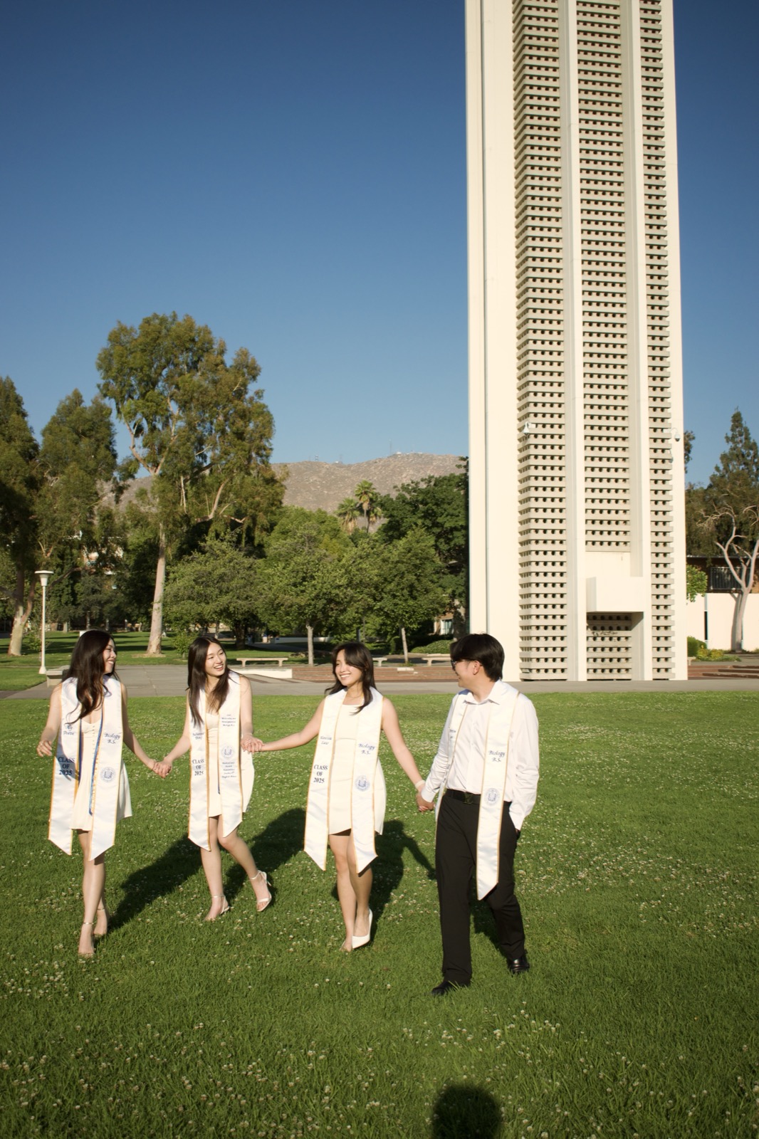Group walking on lawn by bell tower