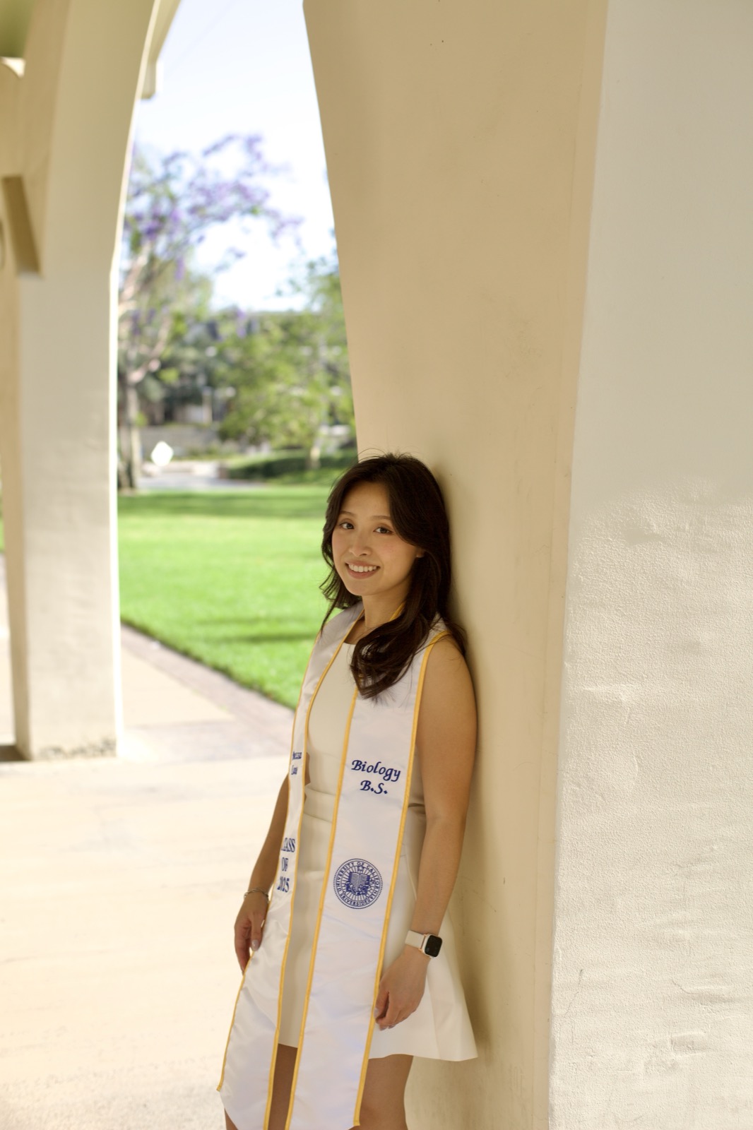 Graduate leaning in archway corridor