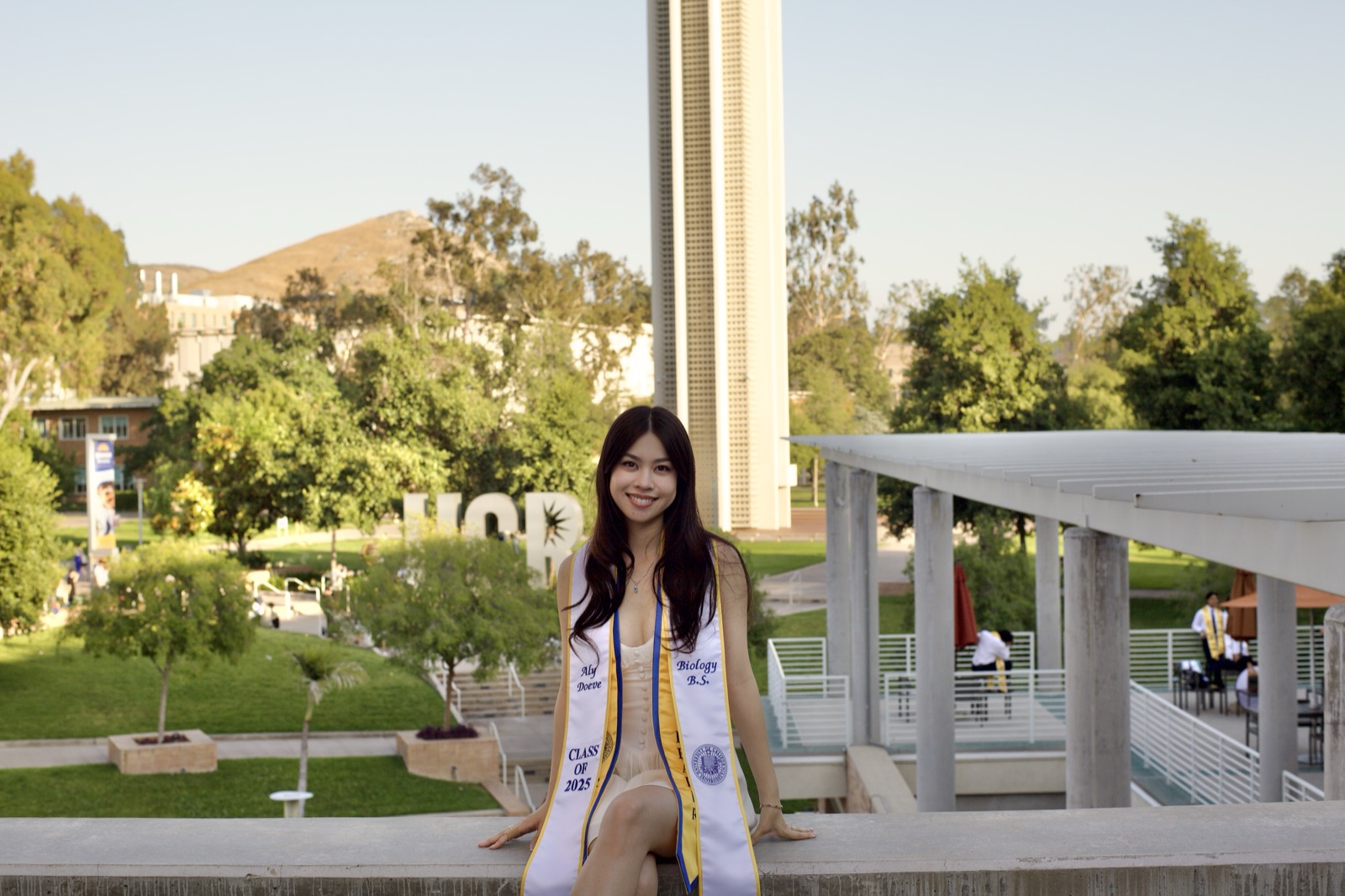 Graduate sitting at campus overlook
